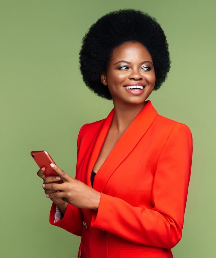 Business woman wearing orange suit with matching phone